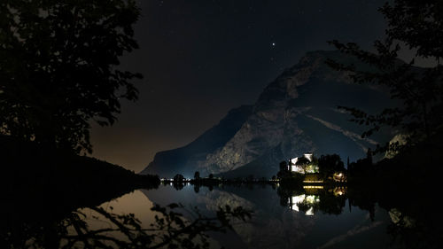 Toblino castle on lake toblino in the evening under the starry sky and mountain