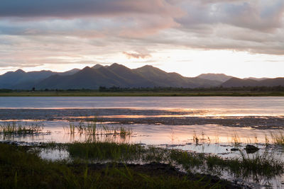 Scenic view of lake against cloudy sky