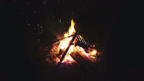 Close-up of illuminated fire against sky at night