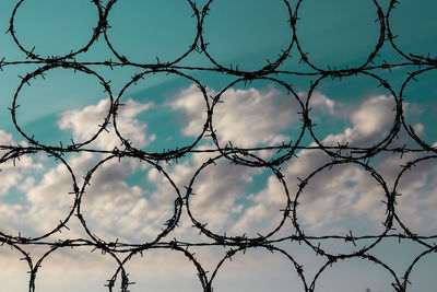 Full frame shot of chainlink fence against blue sky