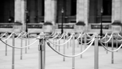 Close-up of metal railing against buildings in city