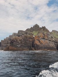 Rock formations by sea against sky