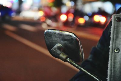 Close-up of hand holding car on street at night