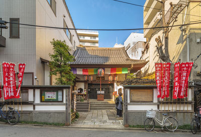 People on street amidst buildings in city