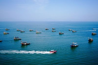 High angle view of boats sailing in sea against clear sky