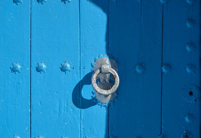 Close-up of knocker on blue door