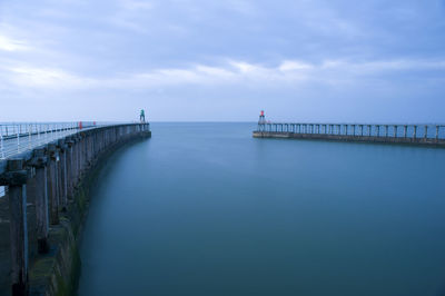 Scenic view of pier in  sea against cloudy sky