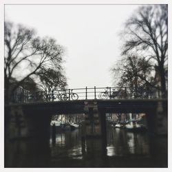 Bridge over river in city against clear sky