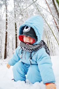 Low angle view of child in snow against trees