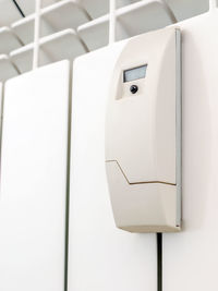 Low angle view of electrical equipment on white wall