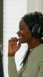 Side view of young woman wearing headphones