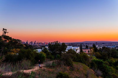 High angle view of trees and buildings against sky during sunset