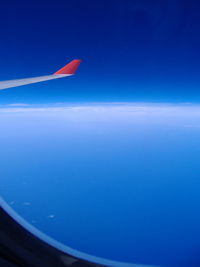 Close-up of airplane wing against clear blue sky