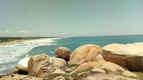Scenic view of rocks on beach against sky