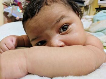 Close-up portrait of cute baby lying on bed