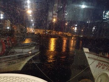 Close-up of wet car windshield in city during rainy season