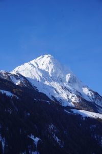 Scenic view of snowcapped mountains against clear blue sky