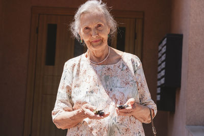 Senior woman with car keys on sunny day