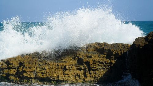 Panoramic view of sea waves splashing on rocks