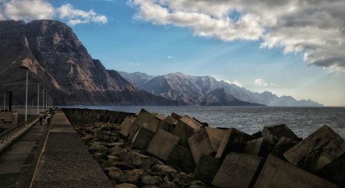 Scenic view of sea and mountains against sky