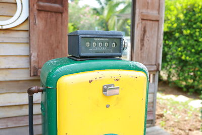 Close-up of yellow mailbox on wood