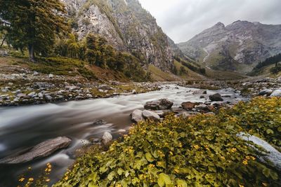 Scenic view of river amidst mountains against sky