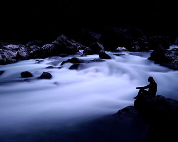 Man looking at waterfall