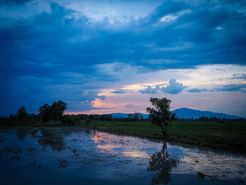 Scenic view of lake against sky at sunset