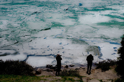 People standing by lake