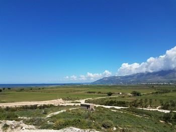 Scenic view of landscape against blue sky