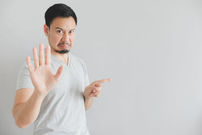 Portrait of man gesturing against white background