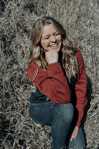 Smiling young woman sitting on field