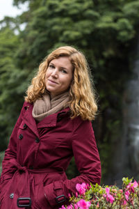 Close-up portrait of young woman against trees