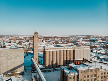 High angle view of buildings in city against clear blue sky