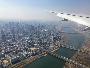 Aerial view of buildings in city against sky