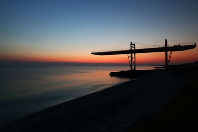 Silhouette of suspension bridge at sunset