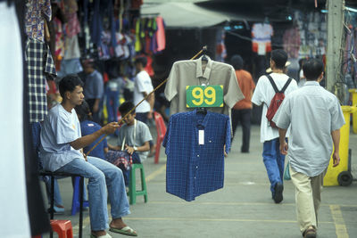 Rear view of people sitting on street in city