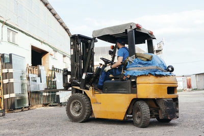 Worker driving forklift and loading glass constructions