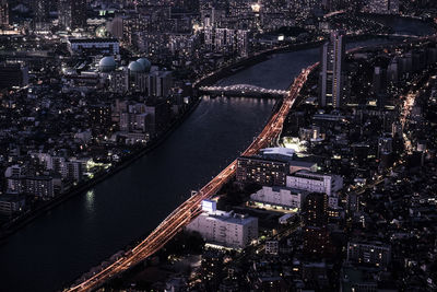 High angle view of river amidst illuminated cityscape