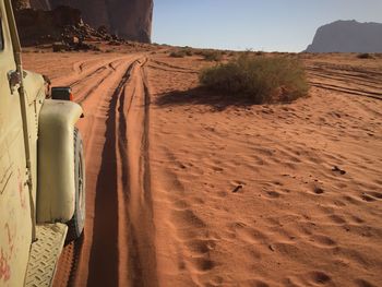 Scenic view of sand dunes at beach against sky