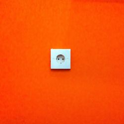 Outlet on orange wall