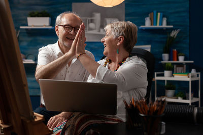Senior couple with laptop enjoying at home