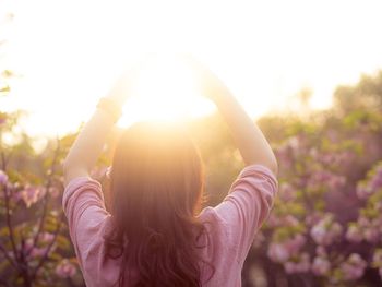 Optical illusion of woman holding sun