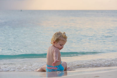 Full length of shirtless boy on beach