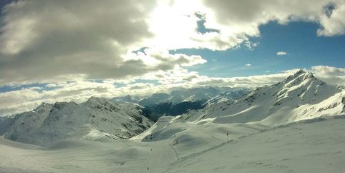 Scenic view of snowcapped mountain against cloudy sky