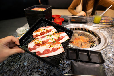 High angle view of person preparing food on barbecue grill