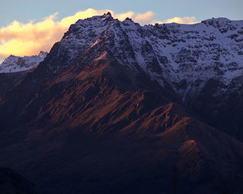 Scenic view of snowcapped mountains against sky during sunset. queenstown, new zealand