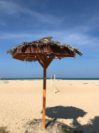 Lifeguard hut on beach against sky