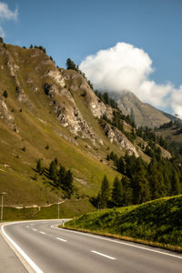 Road by mountains against sky