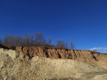 Low angle view of land against clear blue sky